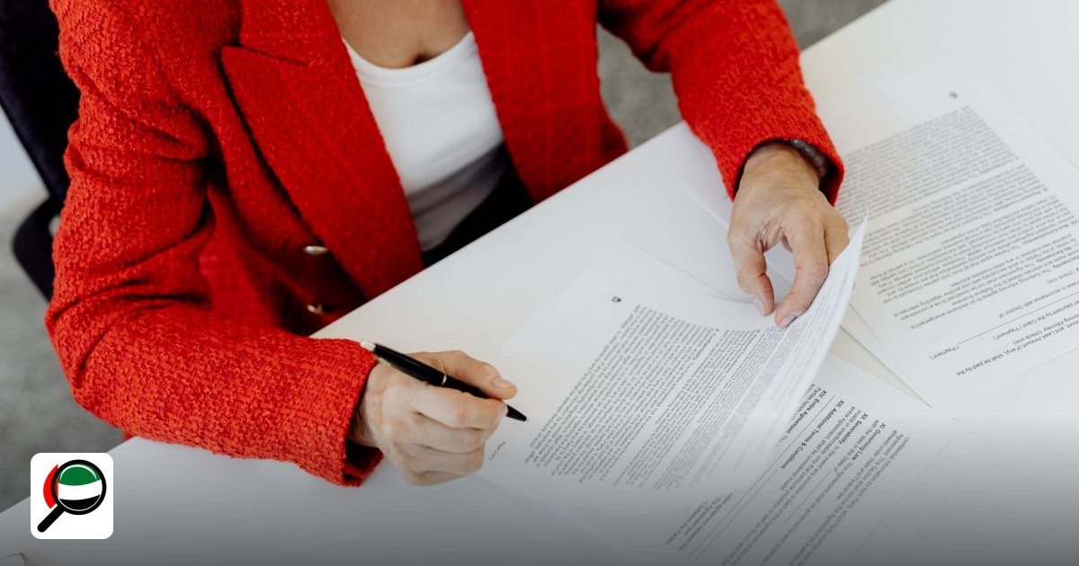 What is an Establishment Card in the UAE? The 2026 Founder’s Guide - woman in red blazer signs paperwork at a desk