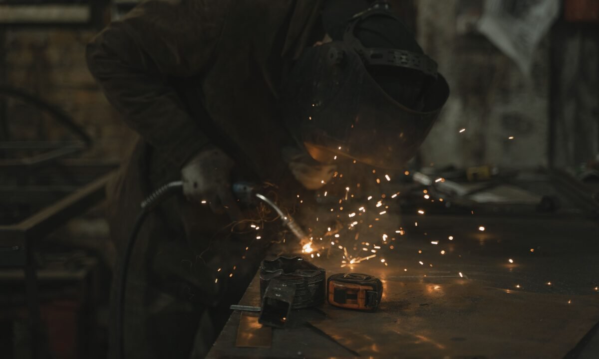Welder working in an industrial workshop for UAE free zone manufacturing licence guide