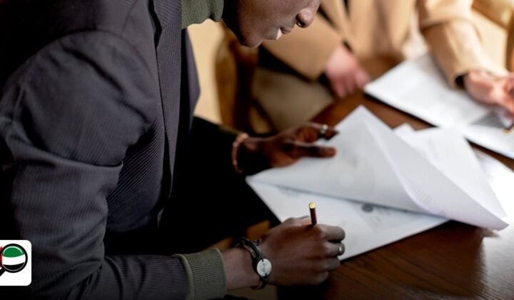 Free Zone Business Events Calendar 2024‑2025 - african man focused on signing important business documents at a desk
