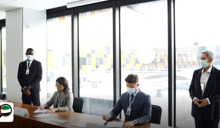 How to Set Up a Company in a UAE Free Zone: Step by Step - colleagues in a meeting room wearing masks, signing documents